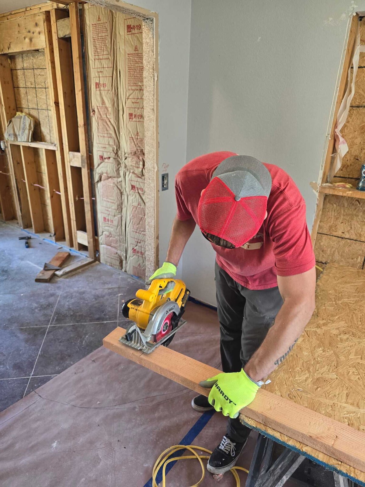 B2 Moving teammate cutting lumber while volunteering on a Habitat for Humanity home project