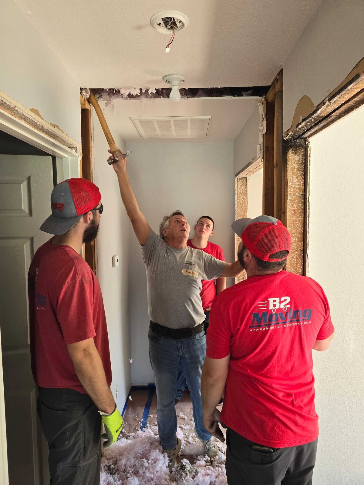 B2 Moving teammates listening to instructions while volunteering on a Habitat for Humanity home project