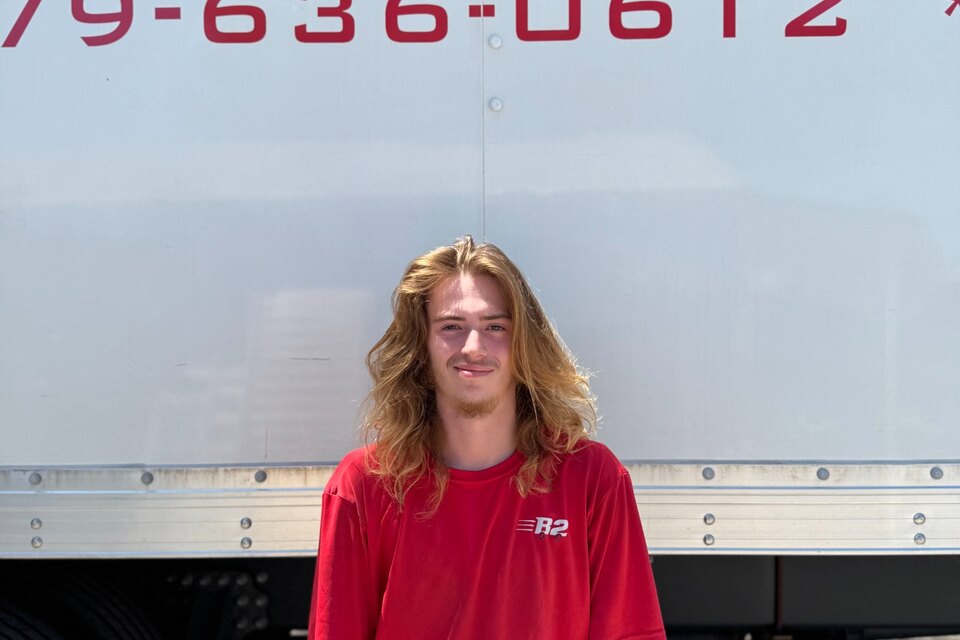 Jacob McKinney, a B2 Moving mover, standing in front of a B2 moving truck