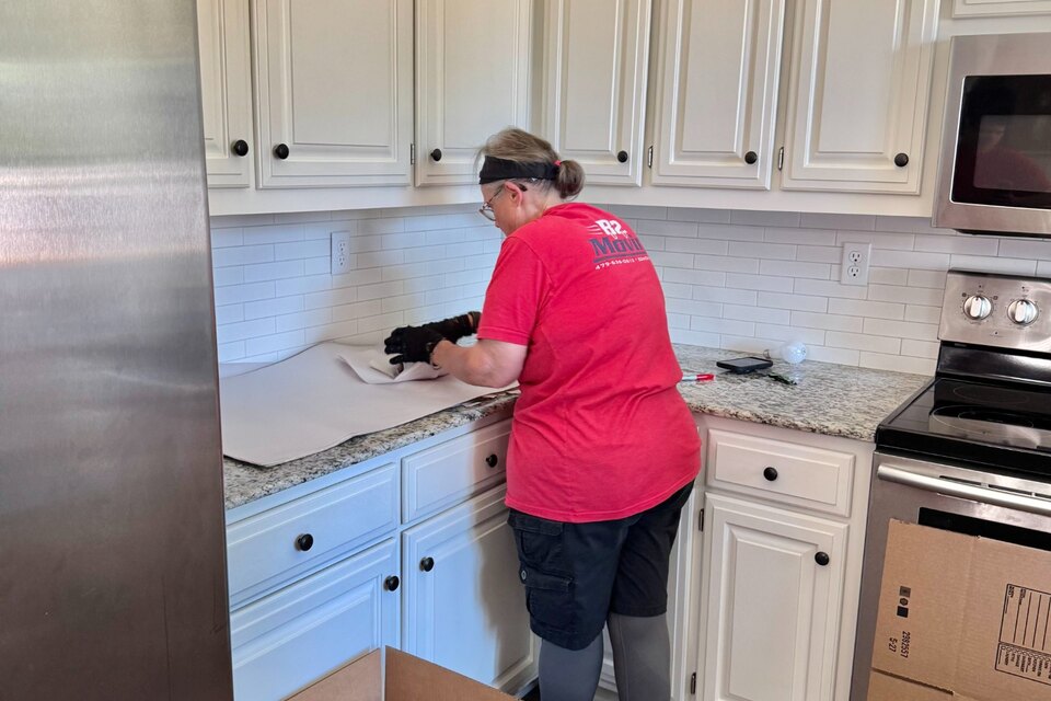 Shirley Baker carefully wrapping delicate kitchen belongings during a B2 Moving pack job