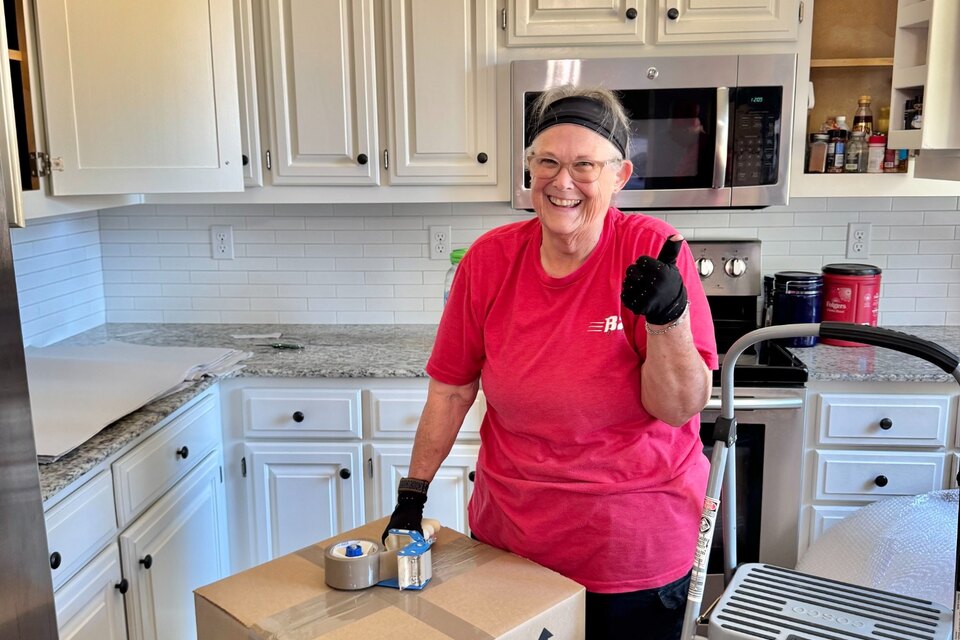 Shirley Baker with a securely packed kitchen box and professional B2 packing materials