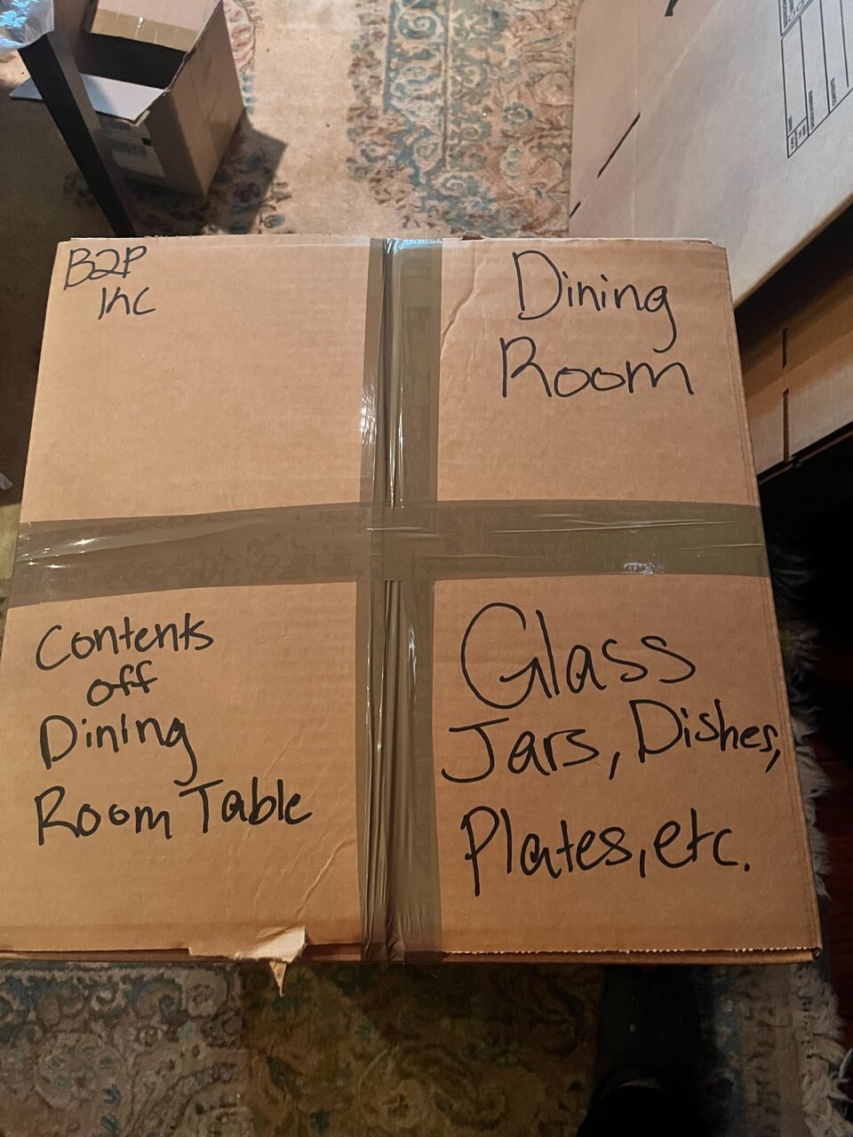Packed box labeled by destination room, contents, and handling needs