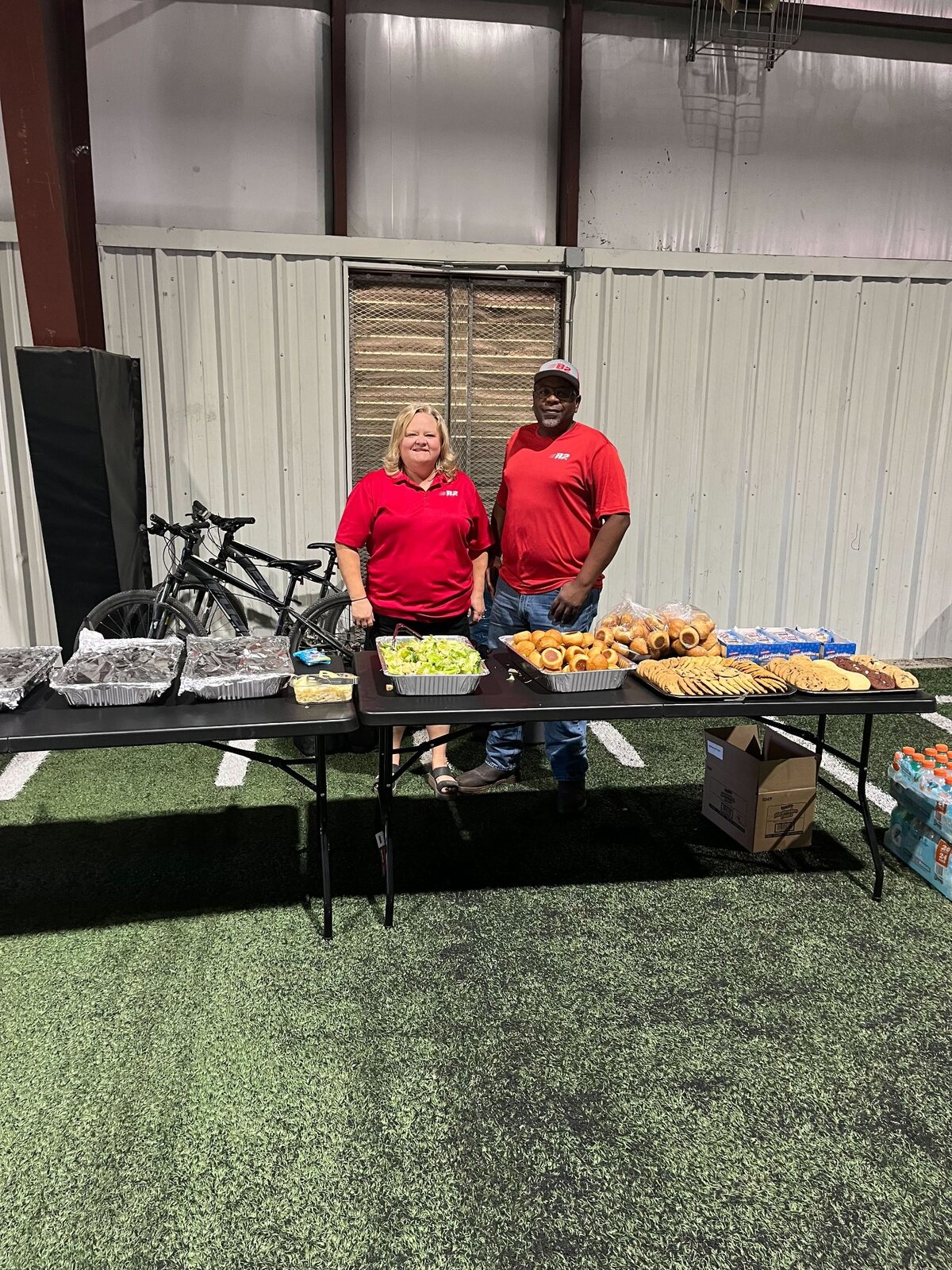 Jill and Jesse serving a catered meal for the Pea Ridge football team