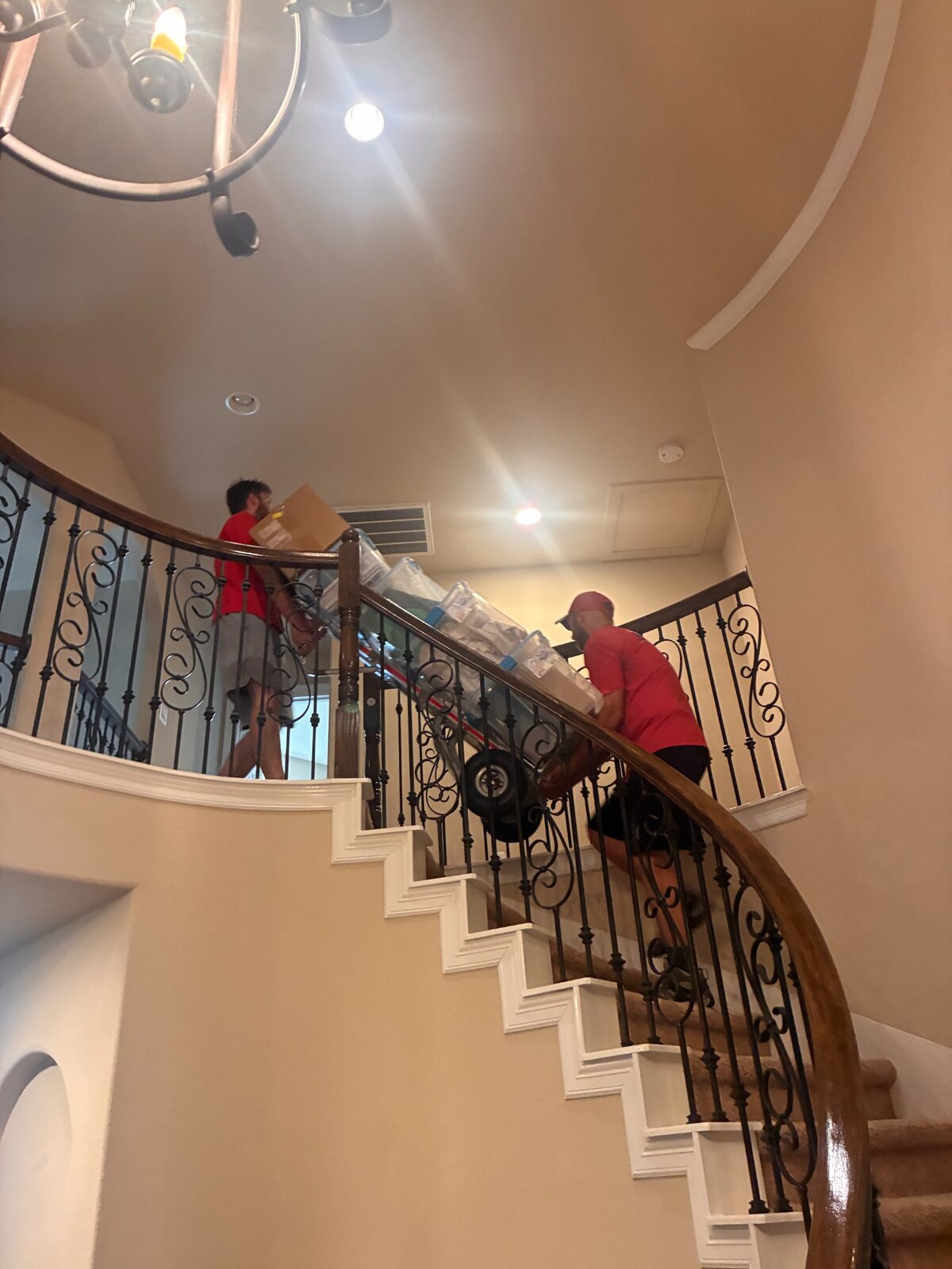 Joe and JT working together to move a loaded dolly upstairs during a Pea Ridge move